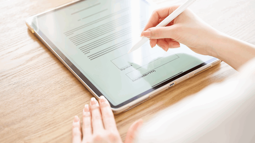 Person signing a digital tax form on a tablet with stylus pen – electronic submission of IR7 declarations through the TFA system in Cyprus.